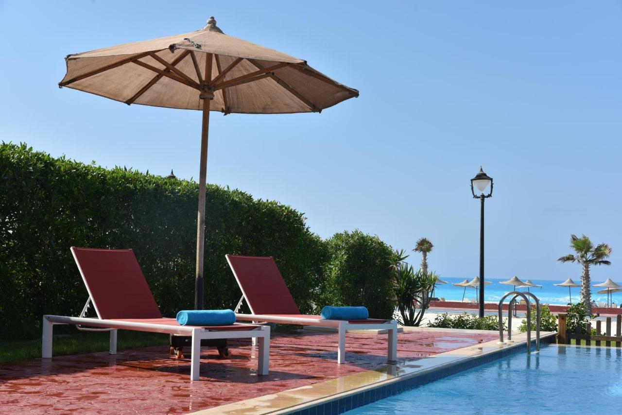 אל עלמיין Tolip North Coast Hotel מראה חיצוני תמונה A poolside umbrella